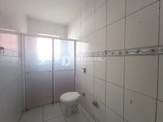 Um banheiro com revestimento cerâmico nas paredes e vaso sanitário.