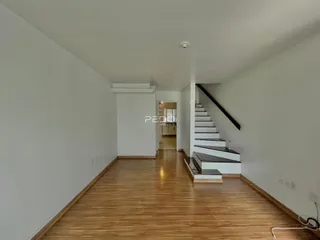 Hall de entrada com piso de madeira e escadaria.