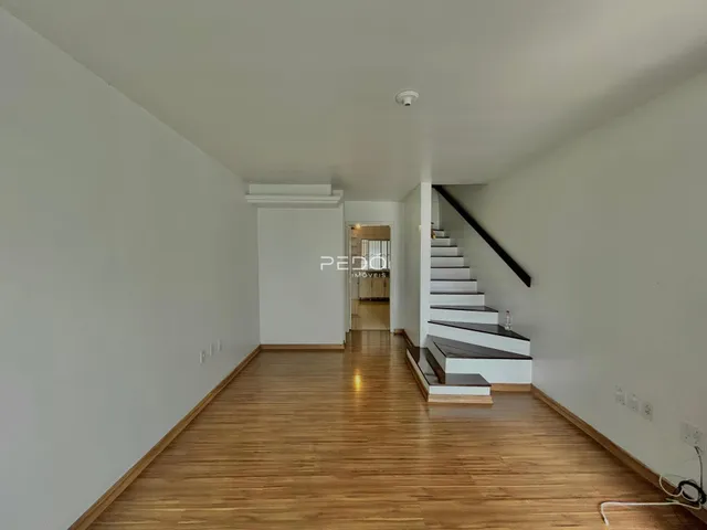 Hall de entrada com piso de madeira e escadaria.