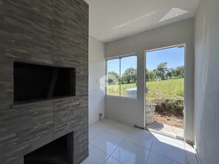 Sala de estar com grande porta de vidro que dá acesso a um campo aberto.