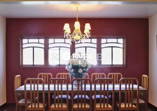 Foto de uma sala de jantar com mesa e cadeiras de madeira.