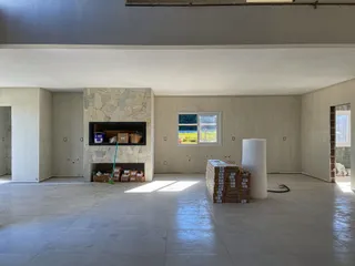 Foto de um ambiente interno amplo com lareira e piso de cerâmica.