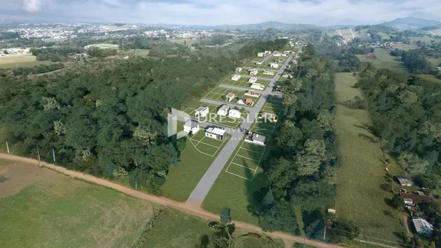 Vista aérea de uma propriedade rural com áreas de vegetação densa e estradas de terra.