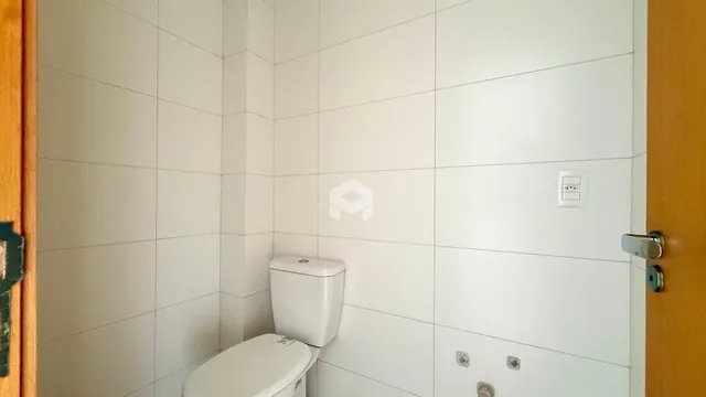 Parede interna de um banheiro com azulejos brancos.