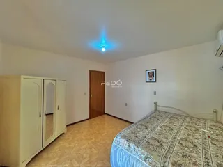 Quarto com cama e armário em ambiente claro.