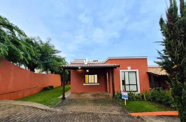 Fachada de uma casa em Lajeado, Brasil, com parede laranja e telhado de telhas.