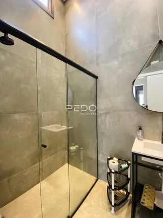 Foto de um banheiro com box de vidro e espelho em um imóvel.