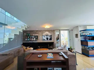 Sala de estar moderna com lareira e sofá grande em um apartamento.