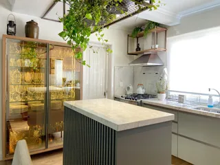 Cozinha moderna com armário de vidro e ilha de mármore.