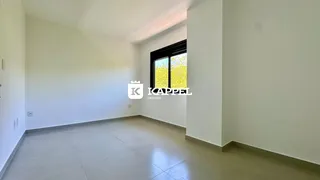 Uma sala ampla e clara com piso de porcelanato e uma grande janela.