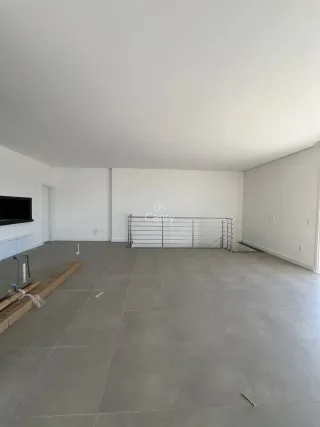 Foto de um ambiente interno amplo e vazio com piso de cerâmica.