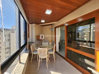 Vista de uma sala de jantar com janela de grande porte e teto de madeira.