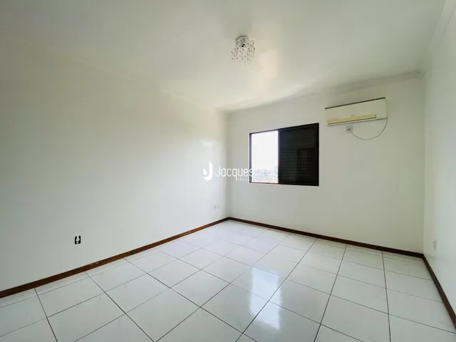 Ambiente interno de uma sala com piso de cerâmica e ar-condicionado instalado.