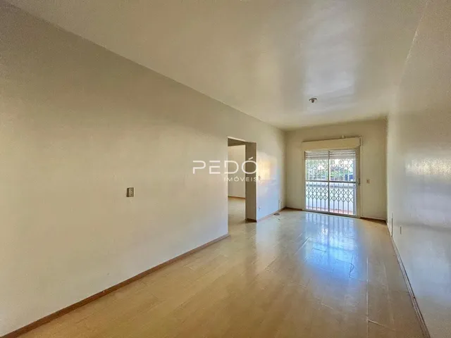 Vista de um corredor interno com piso claro e paredes brancas.