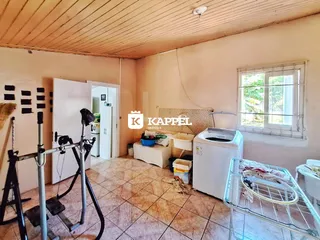 Sala de estar com piso de cerâmica e equipamentos de ginástica visíveis.