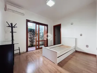 Quarto com cama e porta de vidro em um imóvel em Lajeado.