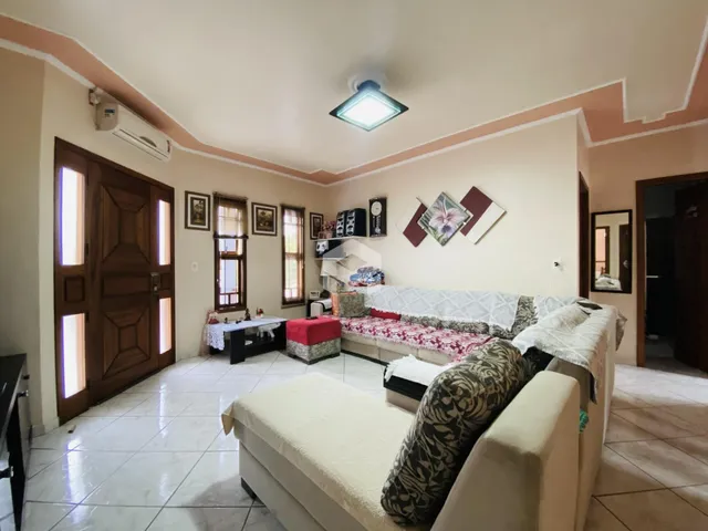 Sala de estar com sofá e portas de madeira em uma residência.