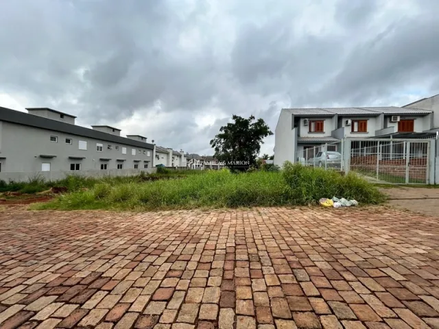 Vista externa de uma área pavimentada com tijolos em frente a edifícios residenciais.