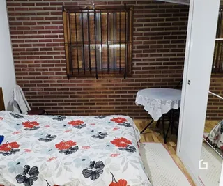 Quarto com parede de tijolos e cama decorada.