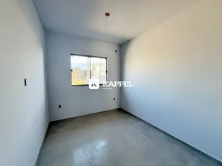 Vista interna de um cômodo com paredes brancas e piso de concreto.