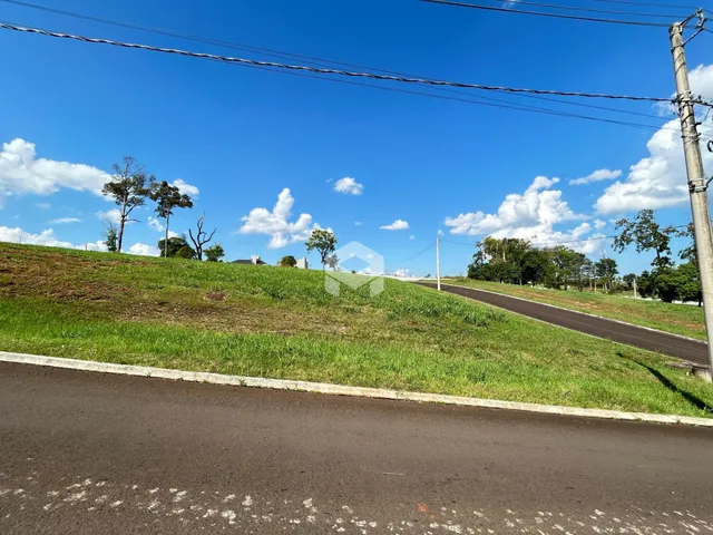 Vista de uma colina verde com uma estrada no primeiro plano.