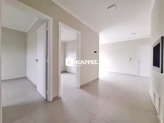 Hall de entrada com piso claro e paredes brancas.