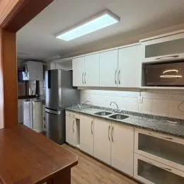 Uma cozinha com armários brancos e bancada é visível na propriedade.