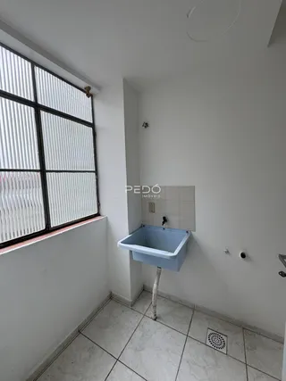 Foto de um ambiente interno com paredes brancas e piso de cerâmica.
