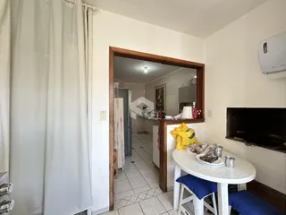 Vista interna de uma sala de estar com acesso à cozinha.