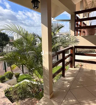 Vista da fachada de uma propriedade em Lajeado, Brasil, com área externa e vegetação.