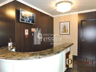 Vista de uma cozinha com armários escuros e bancada de granito.