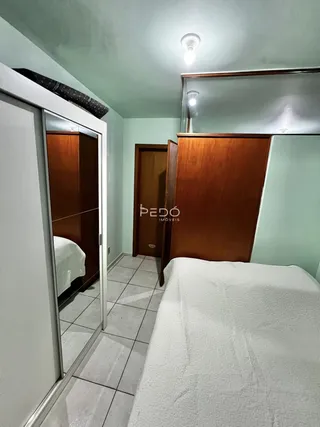 Foto de um quarto com cama e armários de madeira em um imóvel.