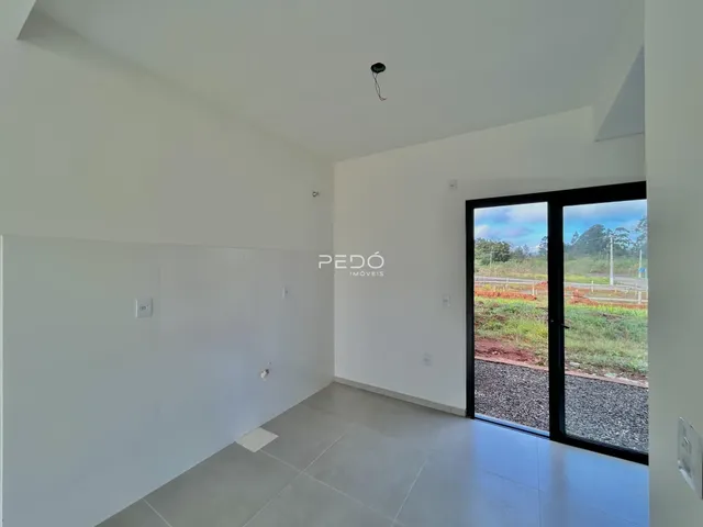 Interior de uma sala com piso de cerâmica e porta de vidro para o exterior.
