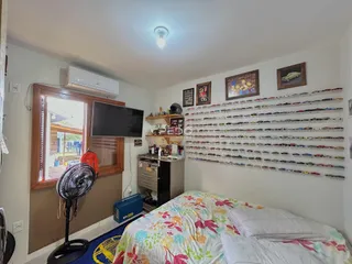 Quarto interno com janela e televisão em uma residência.