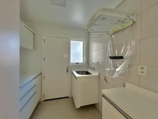 Foto de uma cozinha com armários brancos e piso claro.