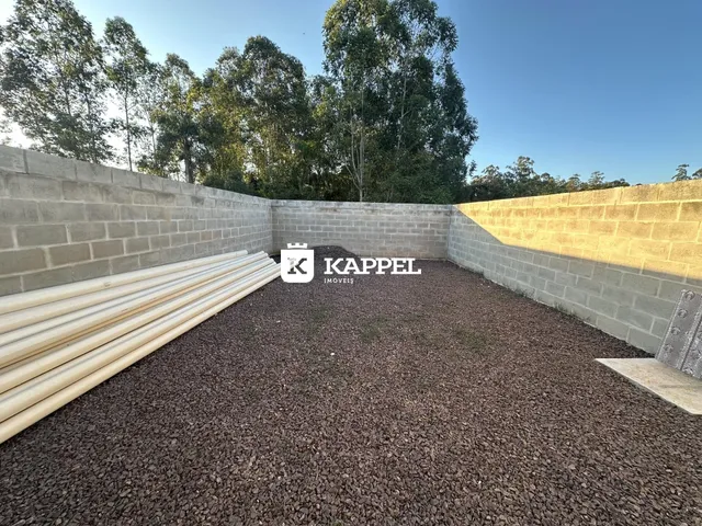 Foto de um terreno externo com piso de cascalho e tubos brancos.