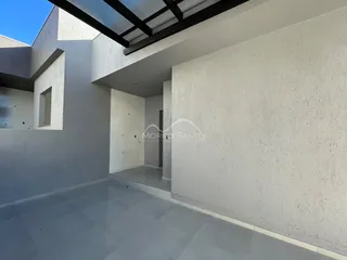 Hall de entrada com piso de porcelanato cinza e estrutura de teto exposta.