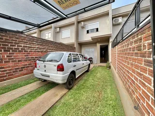 Fachada de uma residência em Lajeado, Brasil, com jardim e carro estacionado na frente.