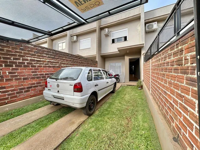 Fachada de uma residência em Lajeado, Brasil, com jardim e carro estacionado na frente.