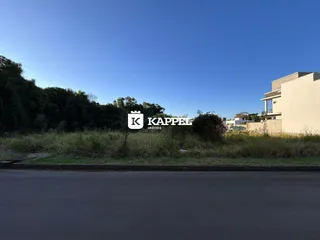 Vista externa de uma residência com vegetação e estrada no primeiro plano.