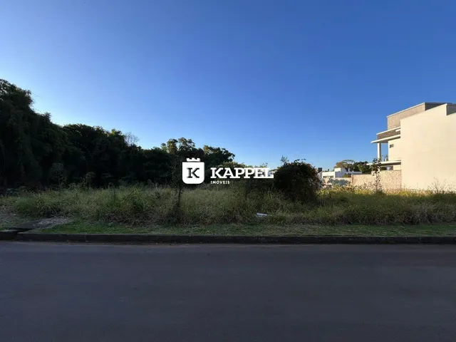 Vista externa de uma residência com vegetação e estrada no primeiro plano.