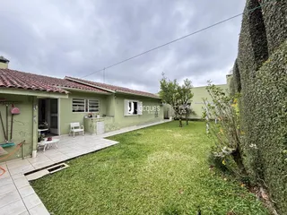 Fachada de casa em Lajeado, Brasil com jardim gramado e parede coberta de hera.