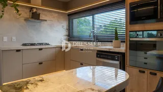 Vista da cozinha com bancadas de mármore e armários modernos.