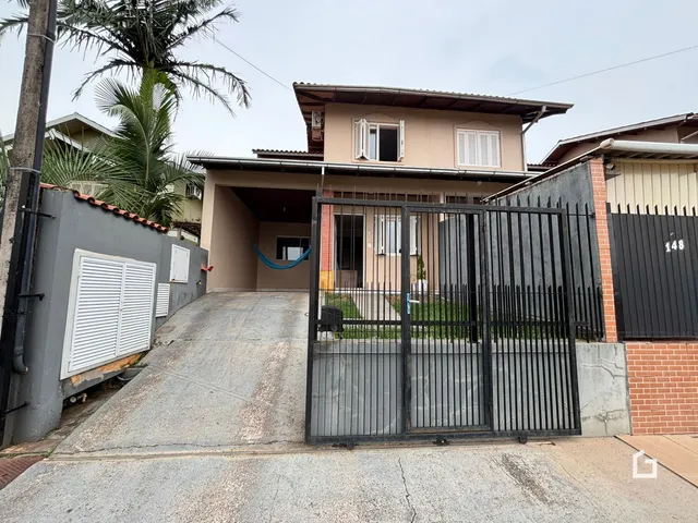 Fachada de uma residência em Lajeado, Brasil, com portão de ferro preto.
