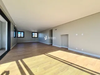 Sala de estar com piso de madeira clara e paredes neutras.