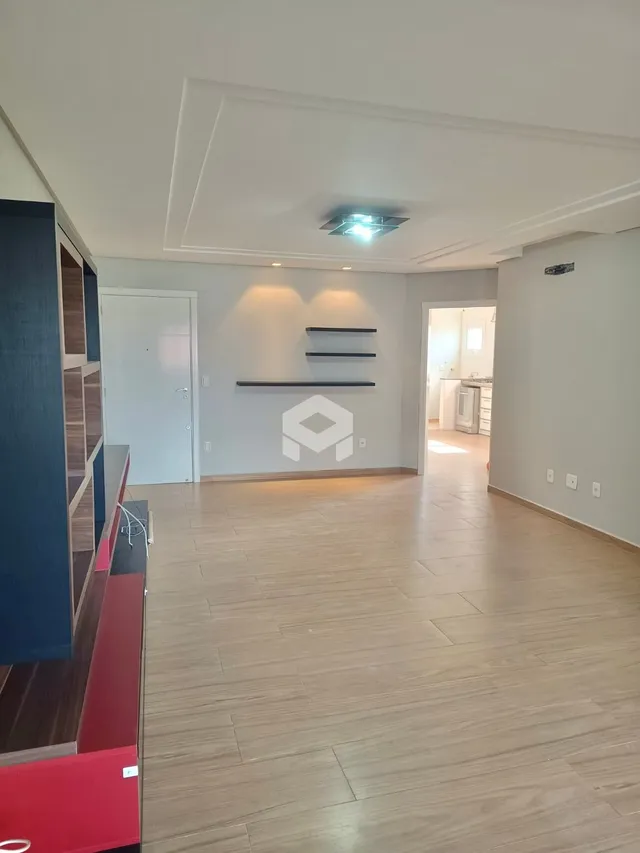 Sala de estar com piso de madeira clara e teto rebaixado.
