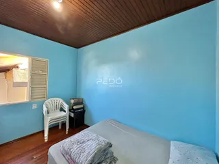 Quarto com paredes azuis e piso de madeira.