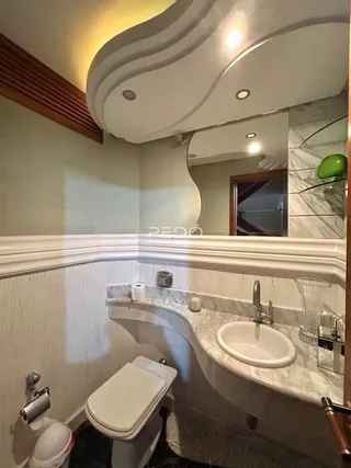 Foto interna de um banheiro com pia e vaso sanitário.