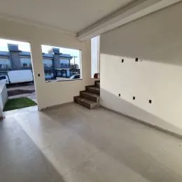 Foto de um espaço interno com piso claro e escadaria.