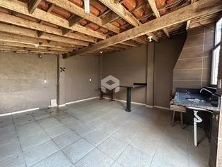 Interior de uma sala com piso de cerâmica e estrutura de madeira exposta.